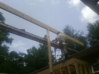 Carpenter setting a ridge beam over a new addition frame — Ice Dam Removal by Roofing Brothers in Angelus Oaks