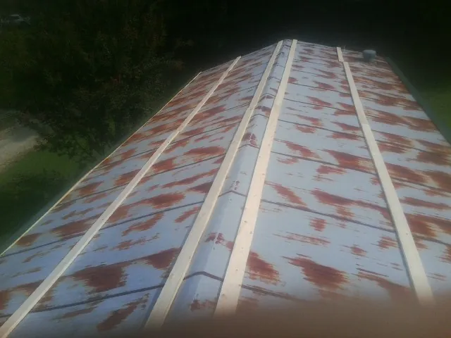 Rusted metal roof panels with new wood purlins before replacement — Storm Damage Roof Repair in Angelus Oaks by Roofing Brothers