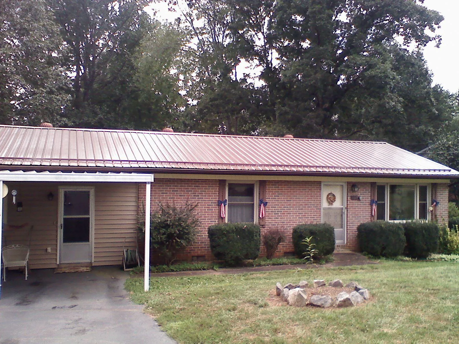 Bronze metal roof and carport on a brick ranch home — Roof Repair work by our crew in Angelus Oaks